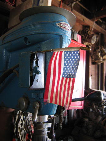 small american flag resting on machinery in garage workshop